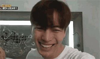 a young man is smiling and looking at the camera in a room .