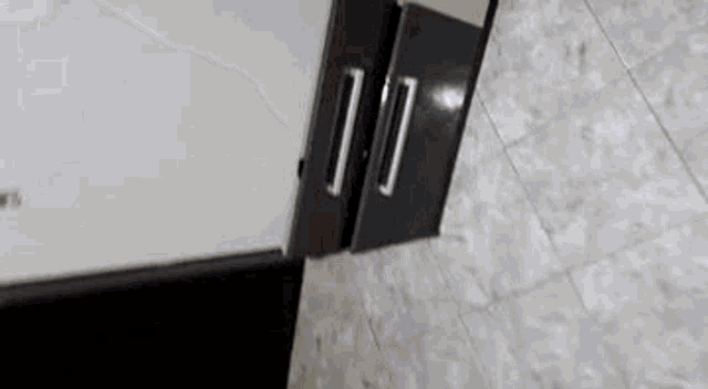 a close up of a door with a handle on a tile floor .