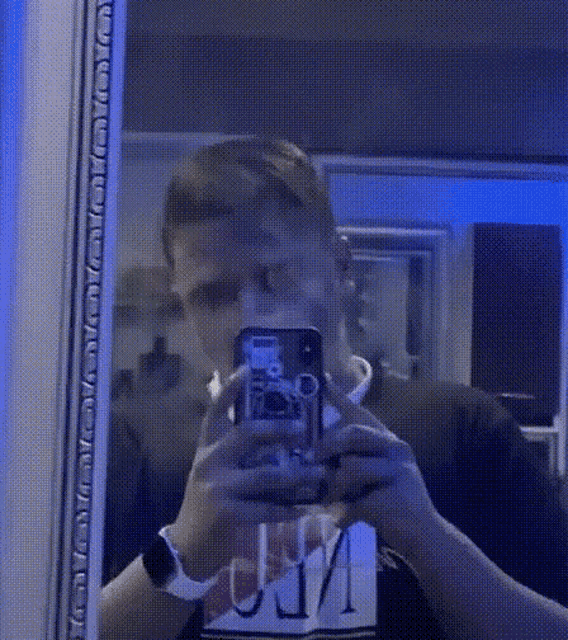 a man taking a picture of himself in a mirror with a phone that says ' selfie ' on it