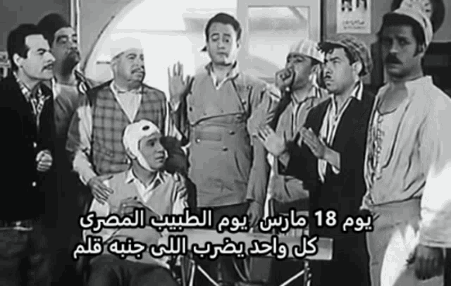 a group of men standing around a man in a wheelchair with arabic writing on the bottom