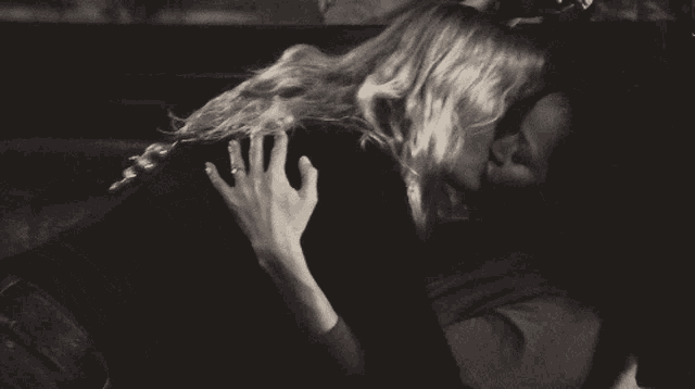 a man and a woman are kissing in a car