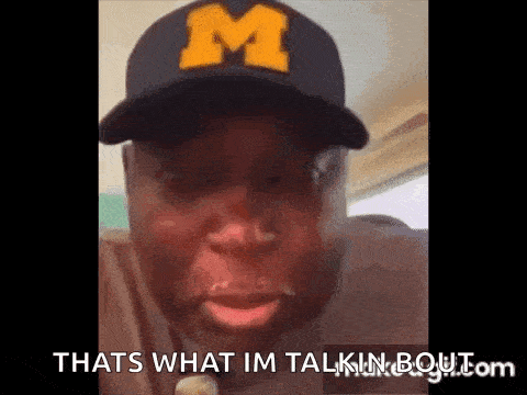 a man wearing a hat with the letter m on it is making a funny face .