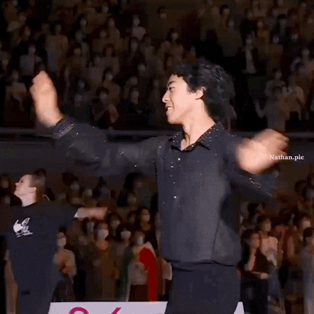 a man in a black shirt is dancing in front of a crowd with nathan.pic written on the bottom right