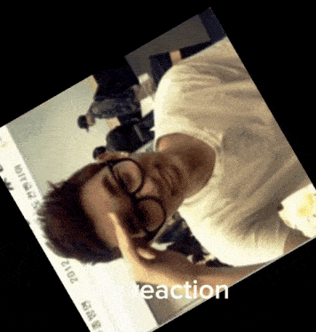 a man wearing glasses and a white shirt with the year 2012 written on it