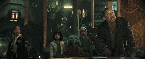 a group of people standing around a table in a room .