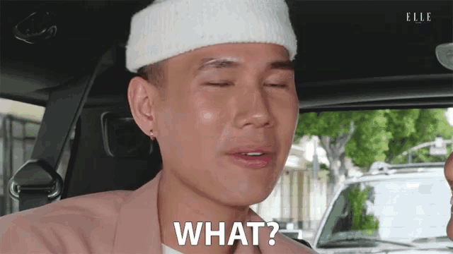 a man wearing a white hat and a pink jacket says " what "