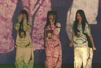 three girls are standing in front of a screen that says ' tokyo ' on it