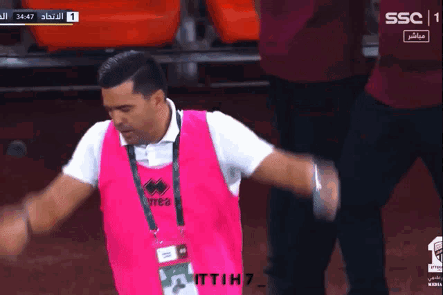 a man wearing a pink vest that says errea