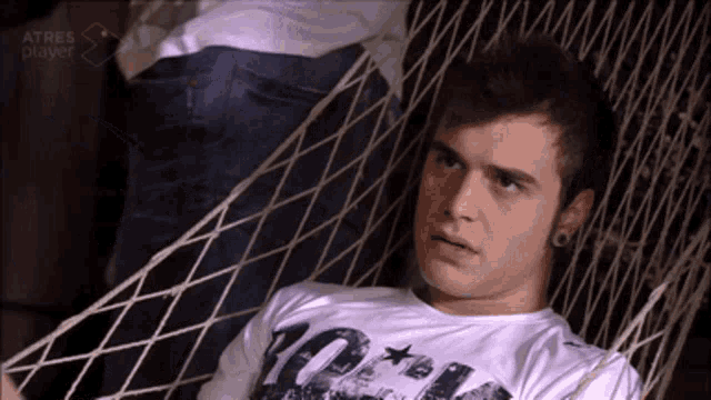 a young man sits in a hammock wearing a t-shirt that says 10 on it