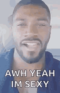 a man with a beard is smiling and says `` aww yeah im sexy '' .