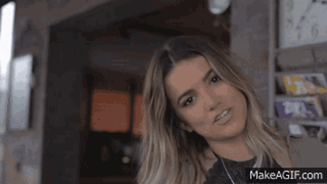 a woman is looking at the camera with makeagif.com in the lower left corner