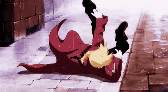 a man in a red coat is laying on his back on the ground .