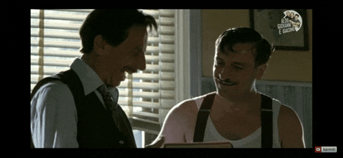 two men are laughing in front of a window and a youtube logo