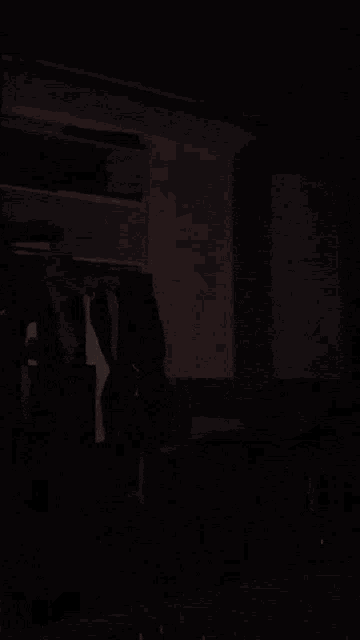 a man in a white tank top stands in front of a closet full of clothes