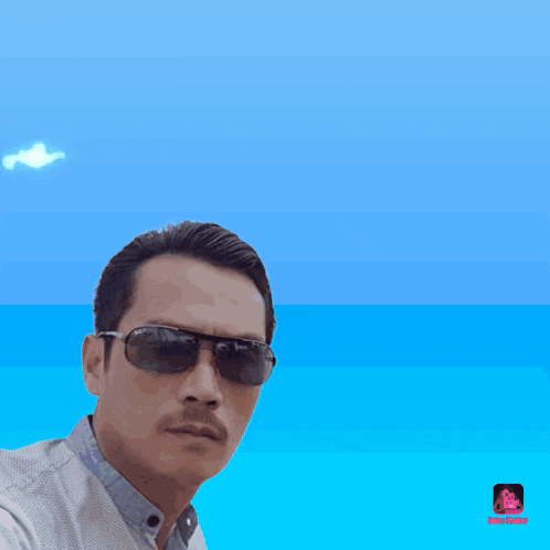 a man wearing sunglasses stands in front of a blue background with the words ng kang written on it