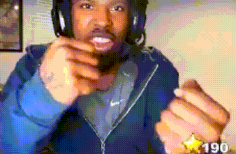 a man wearing headphones and a blue jacket has a gold star on his wrist that says 190