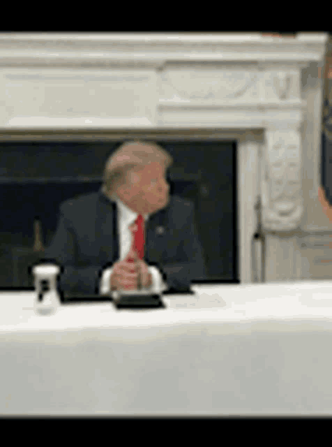 a man in a suit and tie sits at a table