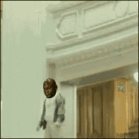 a man wearing a red mask is walking in front of a door