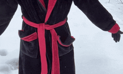 a person wearing a black robe with a red ribbon around the waist