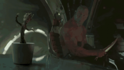 a man is sitting in a vehicle next to a potted plant .