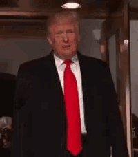 a man in a suit and tie is giving a thumbs up .