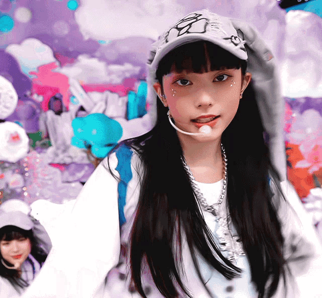 a girl wearing a hat and a necklace has a microphone around her neck