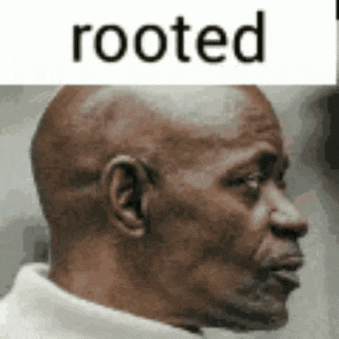 a close up of a man 's face with the words `` rooted '' written above him .