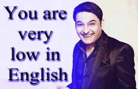 a man in a suit is smiling in front of a sign that says " you are very low in english "