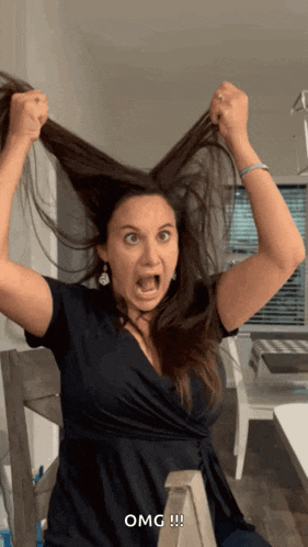 a woman in a black dress is holding her hair up in the air and says omg