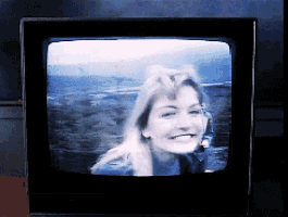 a woman is smiling on a tv screen