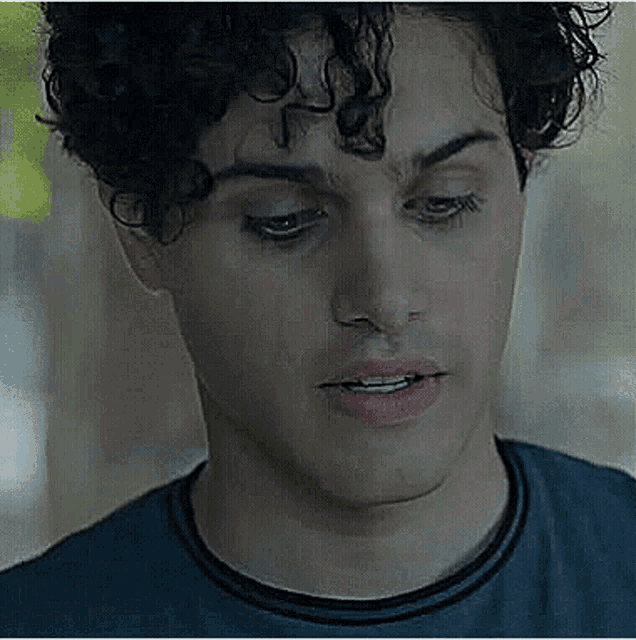 a close up of a man 's face with curly hair .