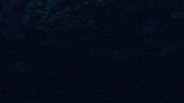 a man in a black cape is standing in a dark room