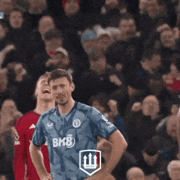 a soccer player in a blue jersey is standing in front of a crowd of people .
