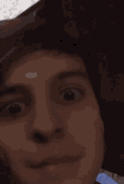 a close up of a person 's face with a surprised look on their face