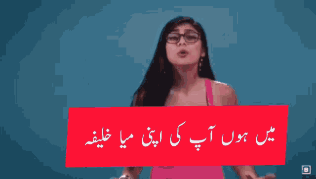 a woman wearing glasses stands in front of a blue background with a red sign that says ' i 'm '
