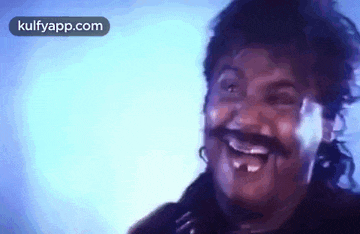 a man with a mustache is laughing with his mouth open .