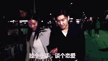 a man and a woman are standing next to each other holding hands .
