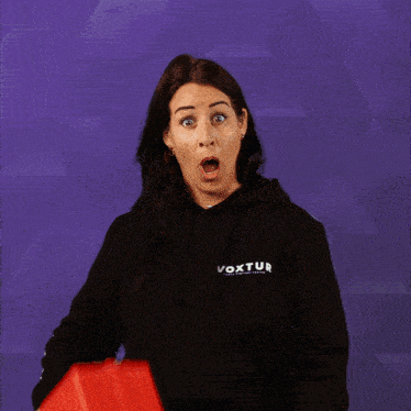a woman holding a red box that says xtur