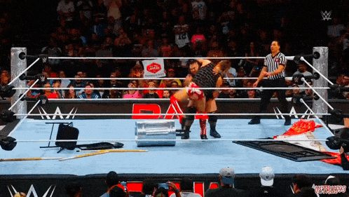 two wrestlers in a wrestling ring with a referee and a sign that says ' gatorade '