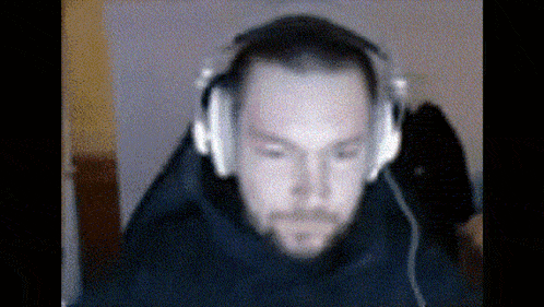 a man wearing headphones looks at the camera