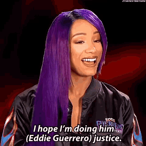a woman with purple hair is wearing a black jacket and smiling .
