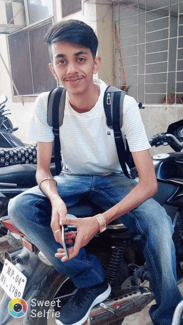 a young man sits on a motorcycle with a license plate that says mf 04