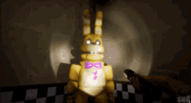 a yellow bunny with a purple bow tie is standing in a dark room