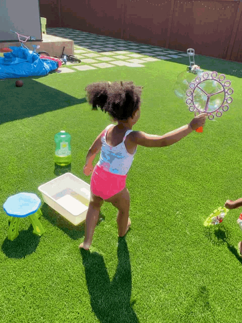 a little girl playing with a soap bubble maker