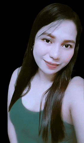 a woman wearing a green tank top is smiling for the camera