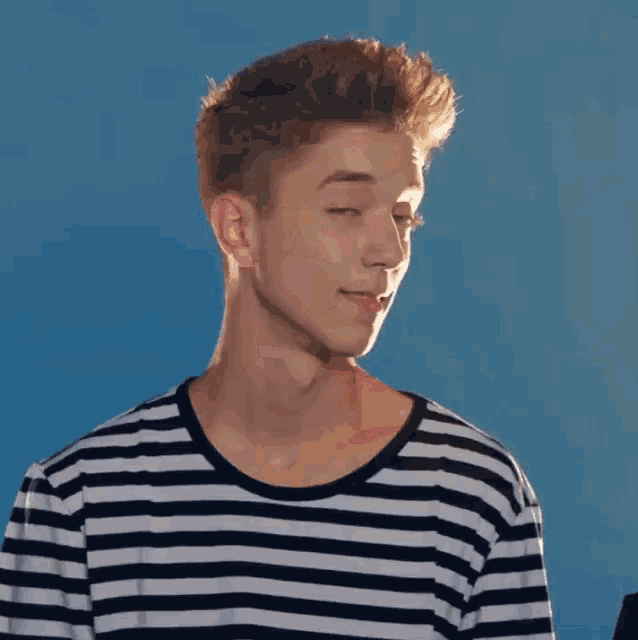 a young man wearing a black and white striped shirt