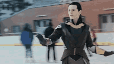 a man in a suit is standing on a ice rink .