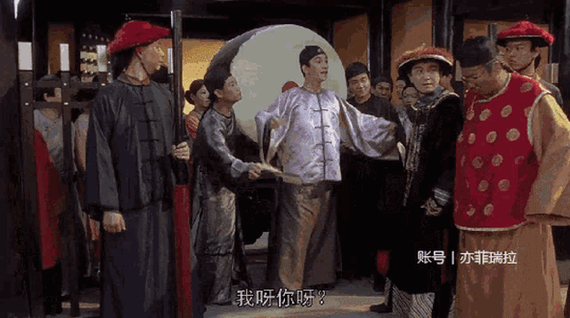a group of people standing in a room with chinese writing on the bottom right