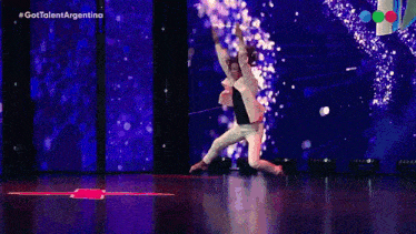 a man is kneeling on the floor on a stage in front of a screen that says gottalent argentina