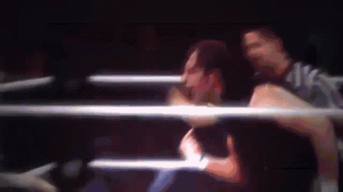a blurry picture of a man in a boxing ring with a referee